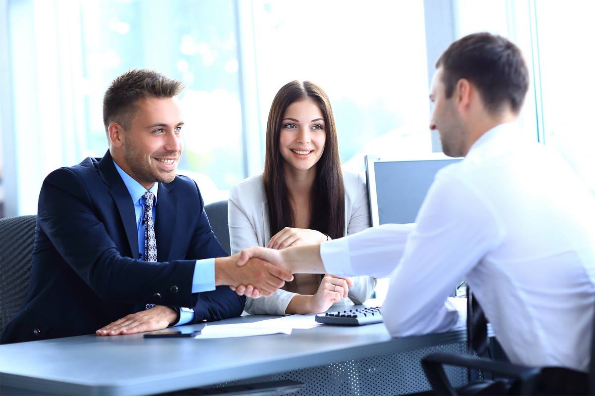 Entrevista de trabajo exitosa entre tres profesionales en una oficina moderna